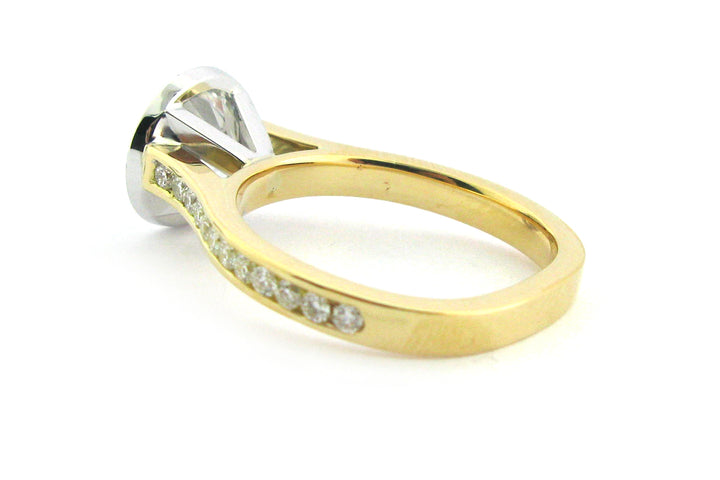 Two tone bezel set round brilliant cut ring with channel set diamond band