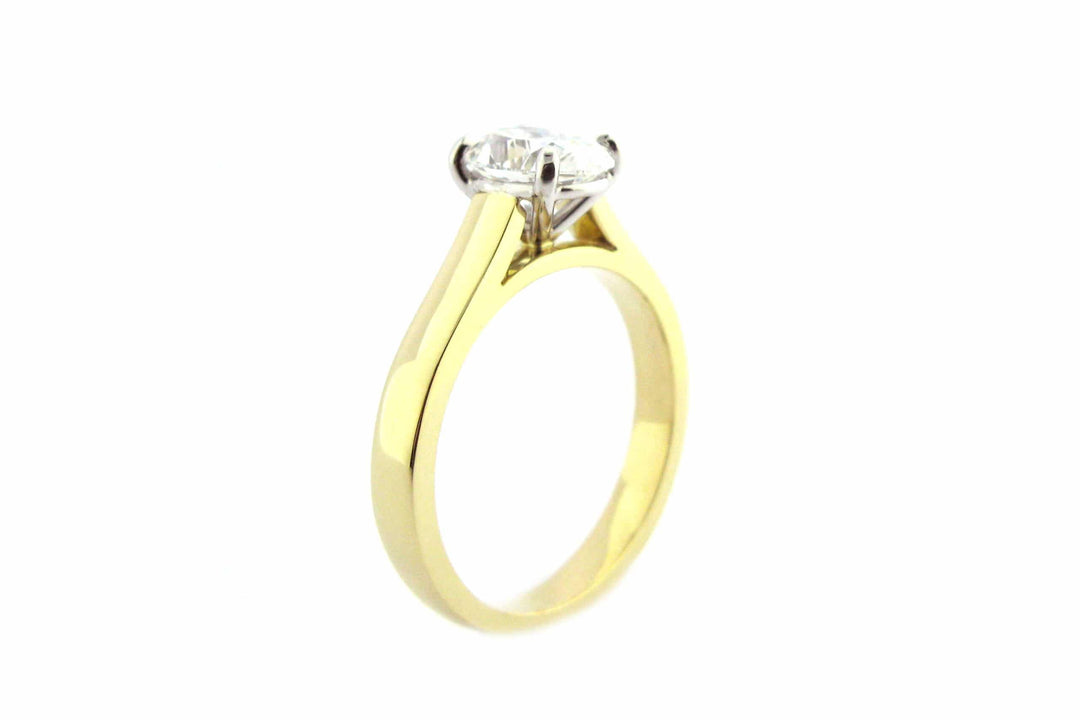 Two tone gold ring with four claw set oval diamond