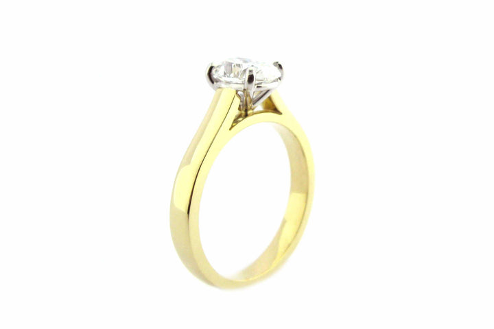 Two tone gold ring with four claw set oval diamond