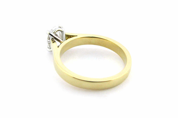 Two tone gold ring with four claw set oval diamond