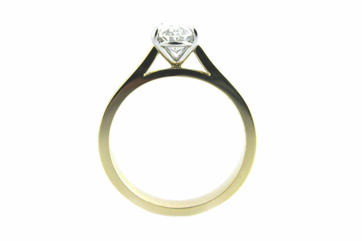 Two tone gold ring with four claw set oval diamond