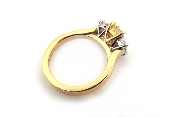 Yellow emerald cut diamond ring with two white emerald cut side diamonds