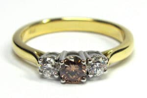 Three stone ring with pink and white round brilliant cut diamonds