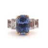 Yellow gold engagement ring with radiant cut sapphire and emerald cut diamonds