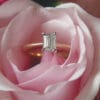 Rose gold engagement ring with talon set emerald cut diamond in pink rose