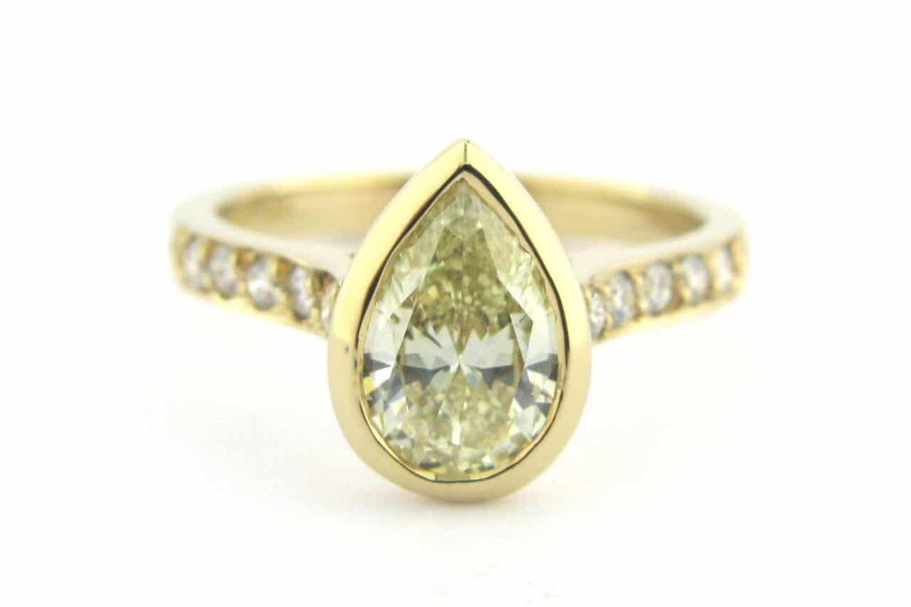 Bezel set pear shape diamond ring with bead set diamonds