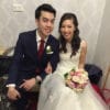 Bride with rose bouquet and groom in suit at wedding ceremony