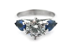six claw set round brilliant cut diamond with pear shaped sapphire sides