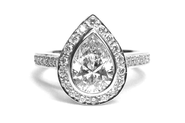 Pear shaped diamond with a halo of diamonds on white gold engagement ring