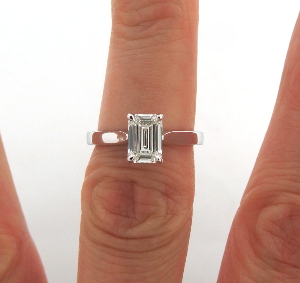 Emerald cut diamond claw set on minimalist white gold band